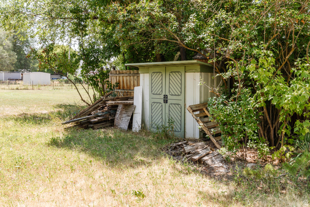342 East 600 North Logan, UT 84321 - Photo 20 of 23 Garden shed with paneled double doors, positioned within a partially shaded area of the property