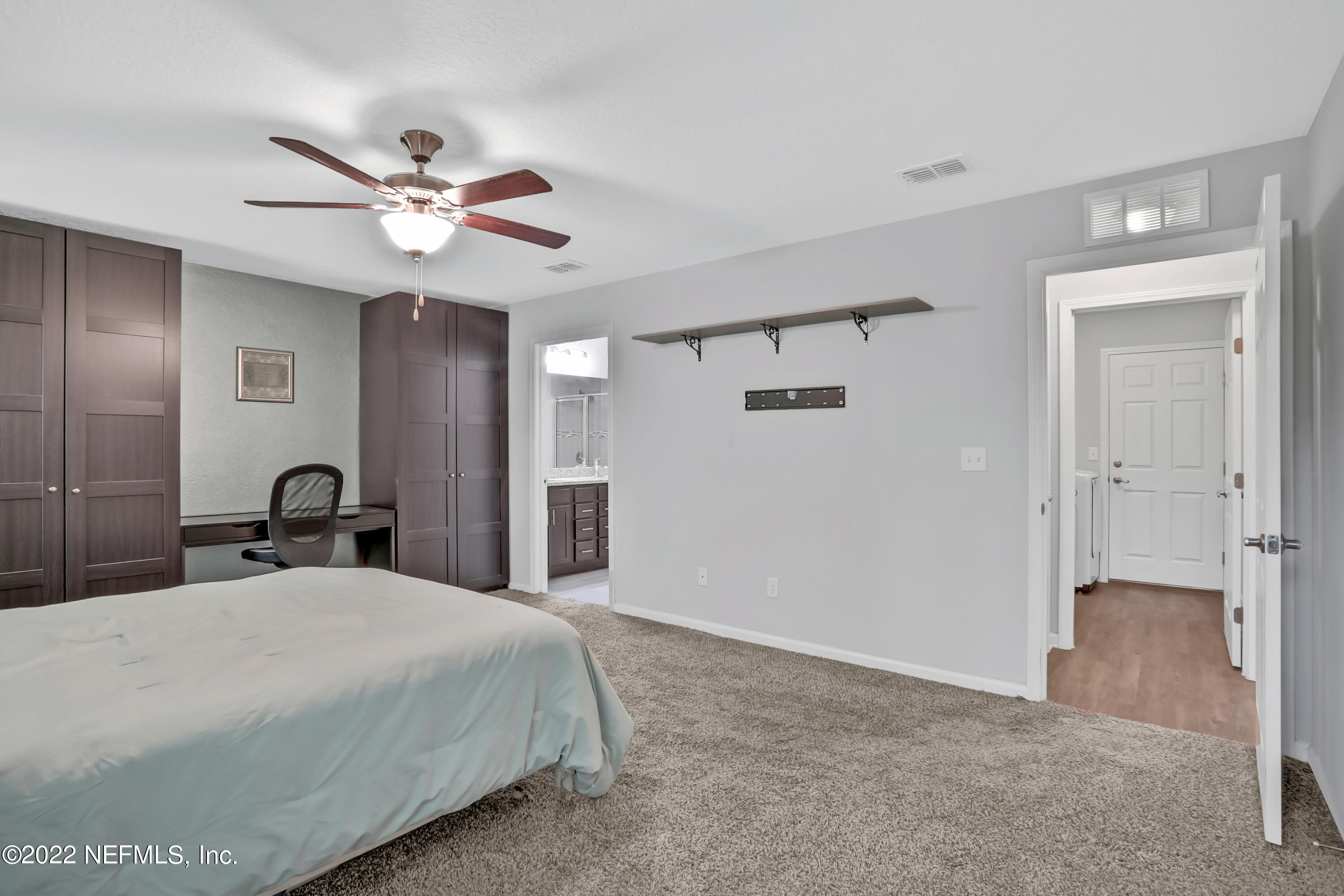 7507 Hilsdale Road Jacksonville, FL 32216 - Photo 18 of 38 a bedroom with a large bed and a chandelier