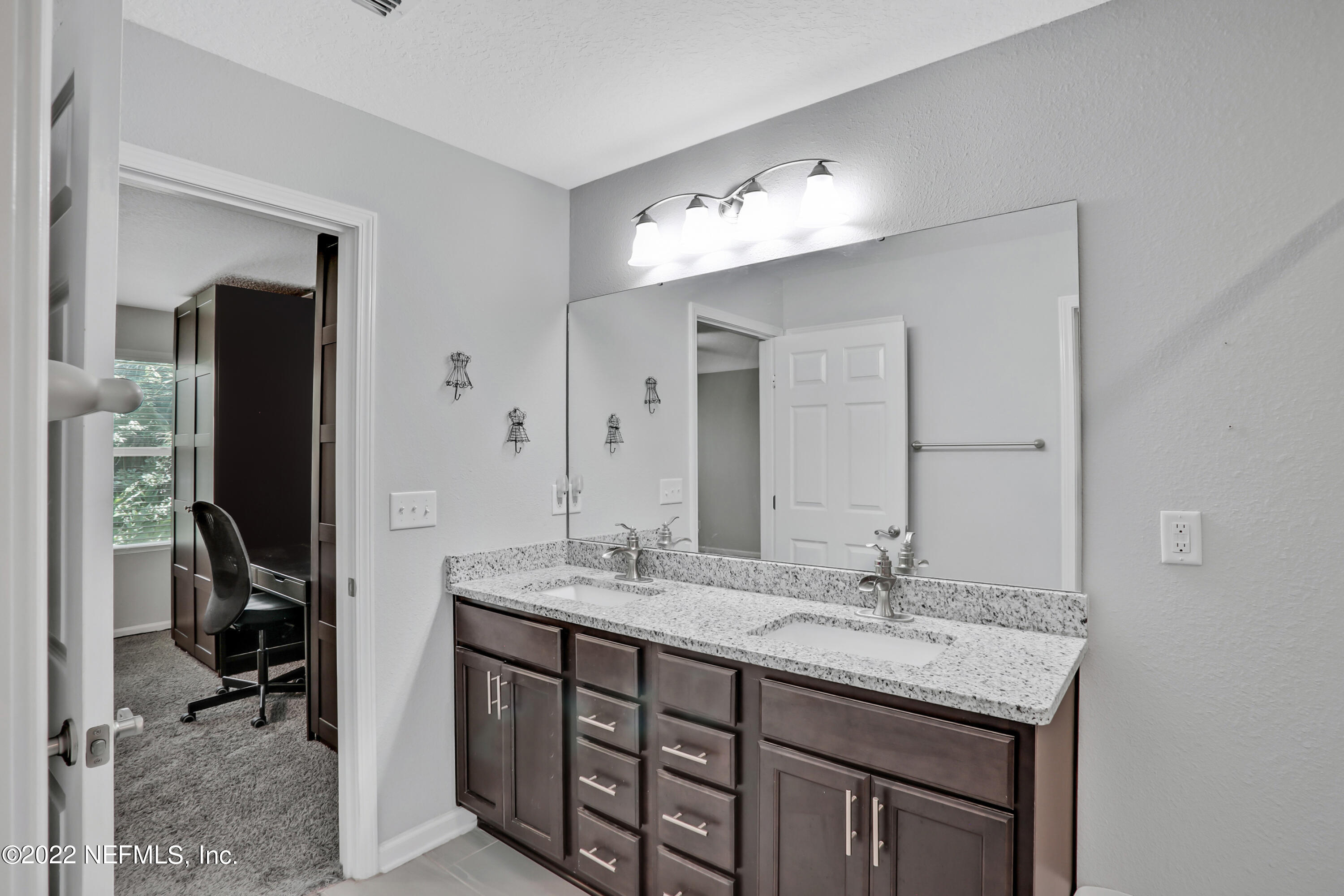 7507 Hilsdale Road Jacksonville, FL 32216 - Photo 20 of 38 a bathroom with a double vanity sink and a mirror