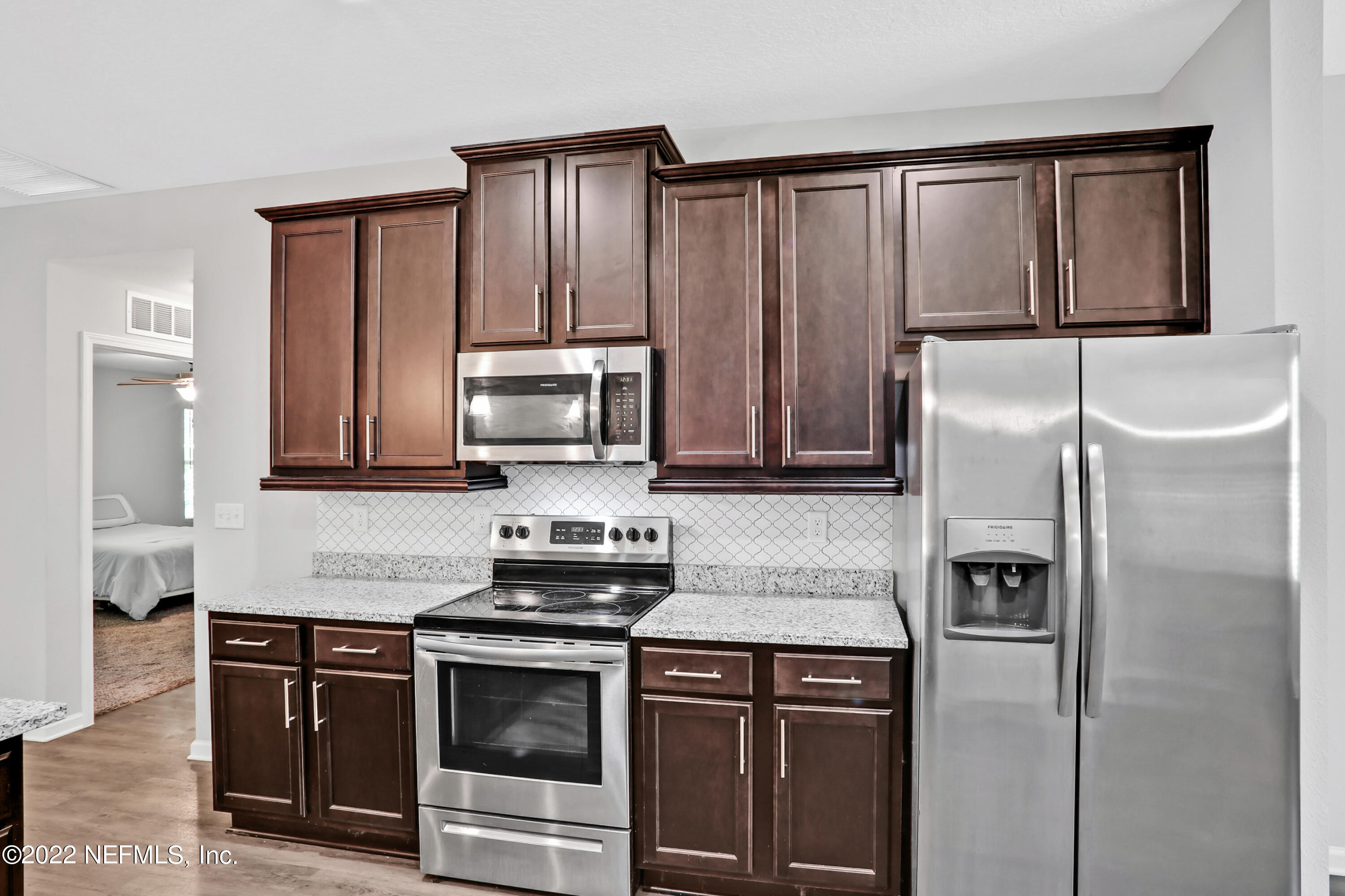 7507 Hilsdale Road Jacksonville, FL 32216 - Photo 7 of 38 a kitchen with granite countertop stainless steel appliances and wooden cabinets