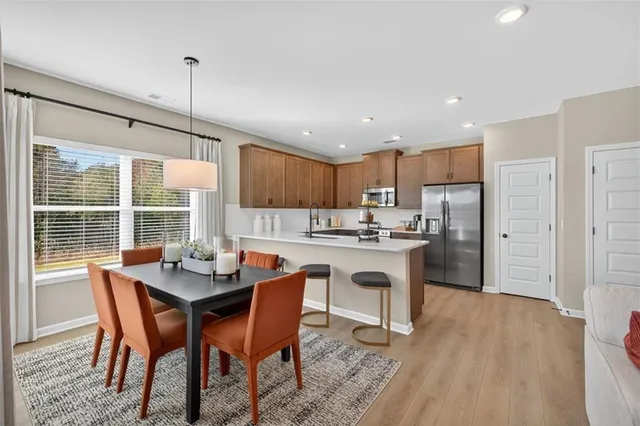 a kitchen with a dining table chairs and refrigerator