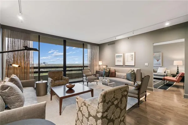 a living room with furniture wooden floor and a large window