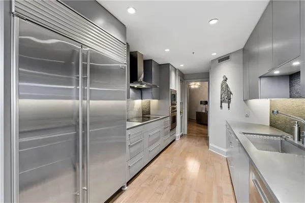 a large kitchen with stainless steel appliances kitchen island a large counter top and a refrigerator