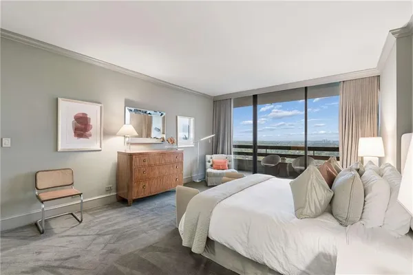 a bedroom with a bed and a dresser next to a window