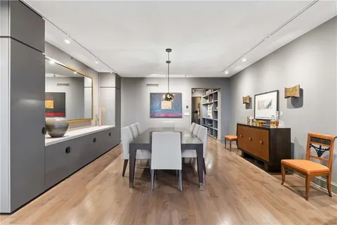 a dining room with furniture a chandelier and wooden floor