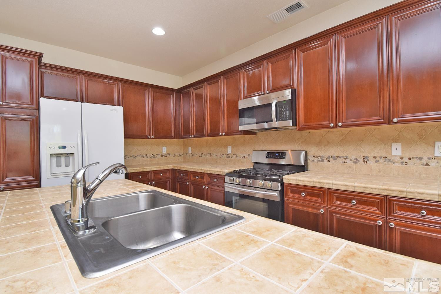 1955 Angel Ridge Drive Reno, NV 89521 - Photo 11 of 33 a kitchen with stainless steel appliances granite countertop a sink stove and cabinets