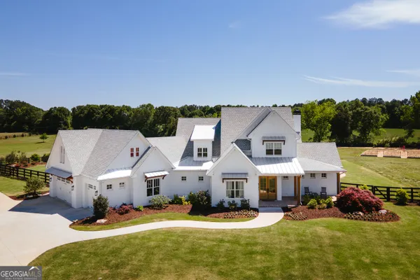 an aerial view of a house with swimming pool garden and patio