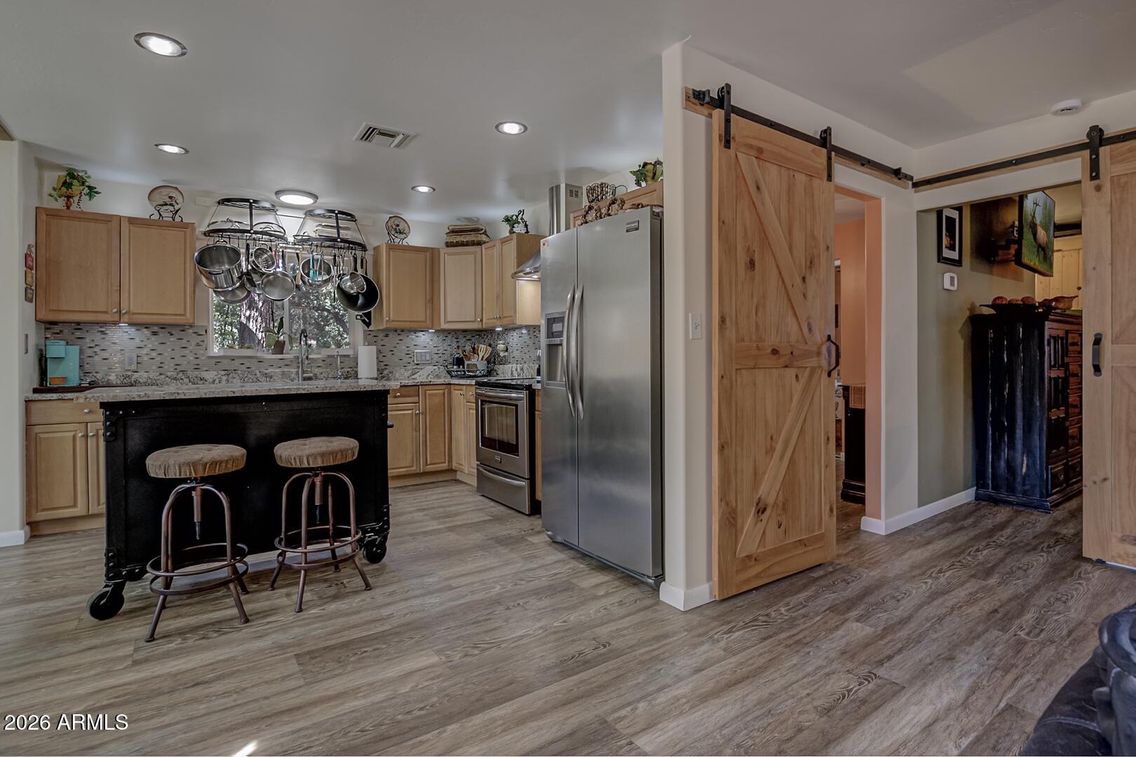 3762 Watertank Road Pine, AZ 85544 - Photo 7 of 38 a kitchen with stainless steel appliances granite countertop a refrigerator a stove and a dining table with wooden floor