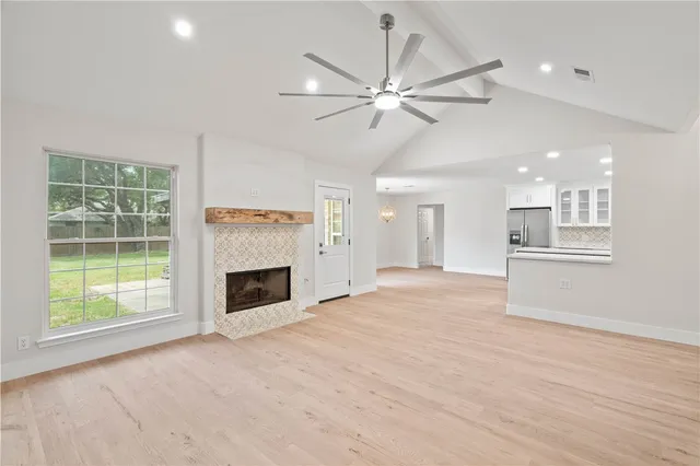 a view of an empty room with a fireplace and a window