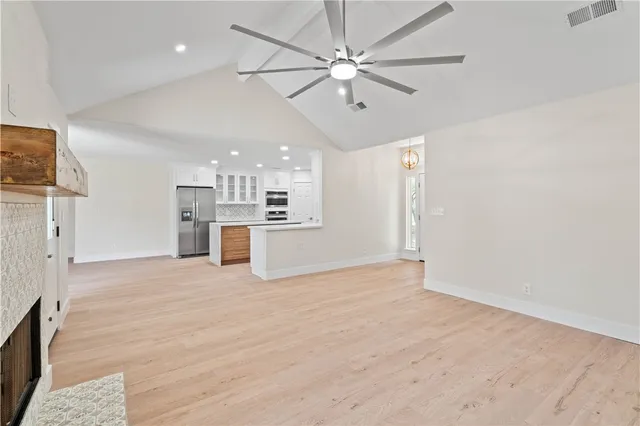 a view of empty room with wooden floor and ceiling fan