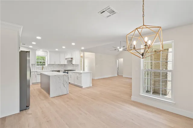 a view of a kitchen with kitchen island and stainless steel appliances
