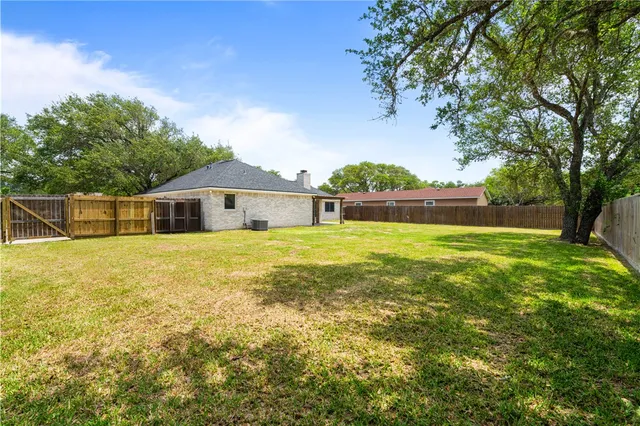 a front view of a house with yard and tree