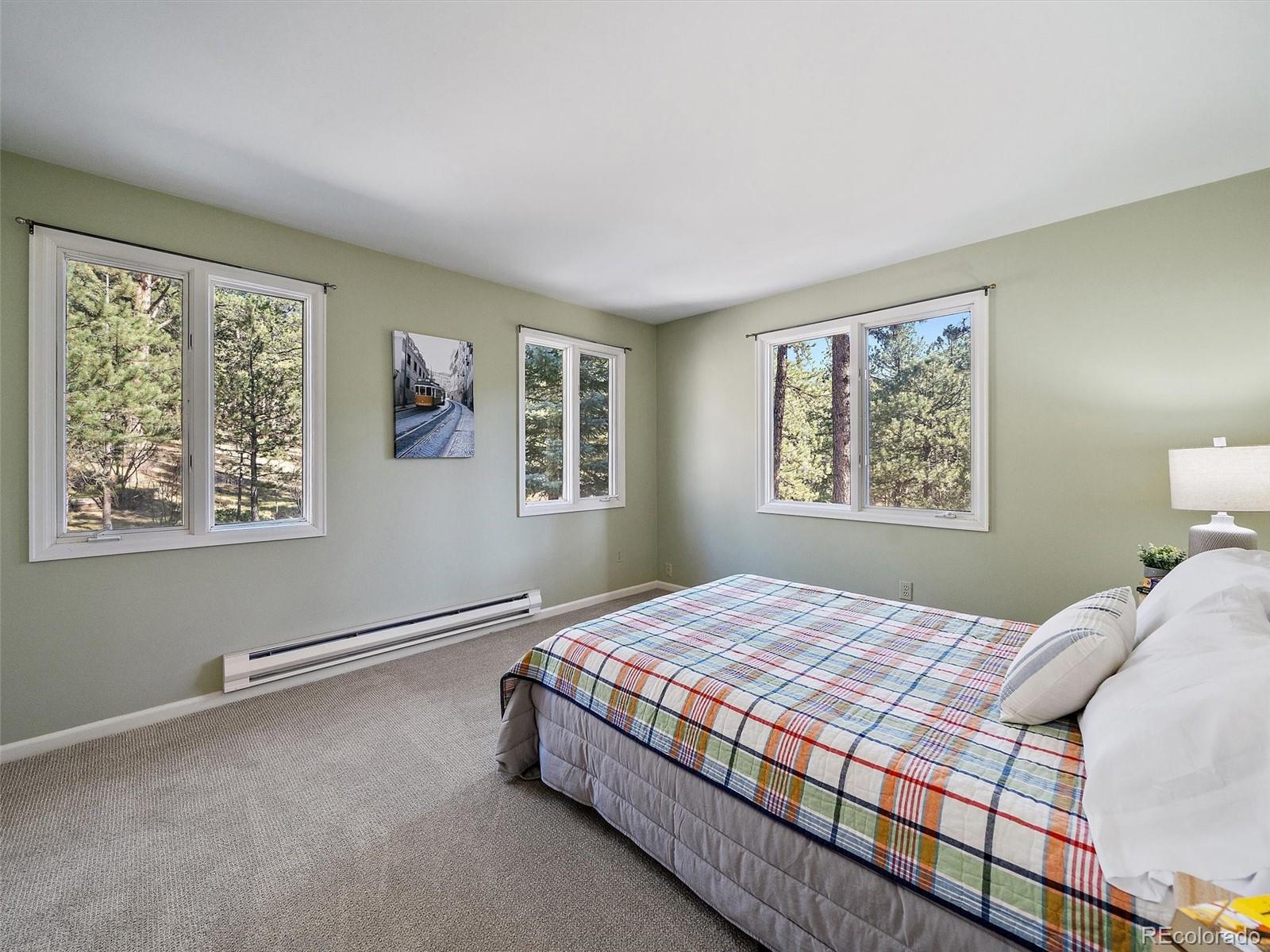 33913 Upper Bear Creek Road Evergreen, CO 80439 - Photo 28 of 45 a bedroom with a bed and a window