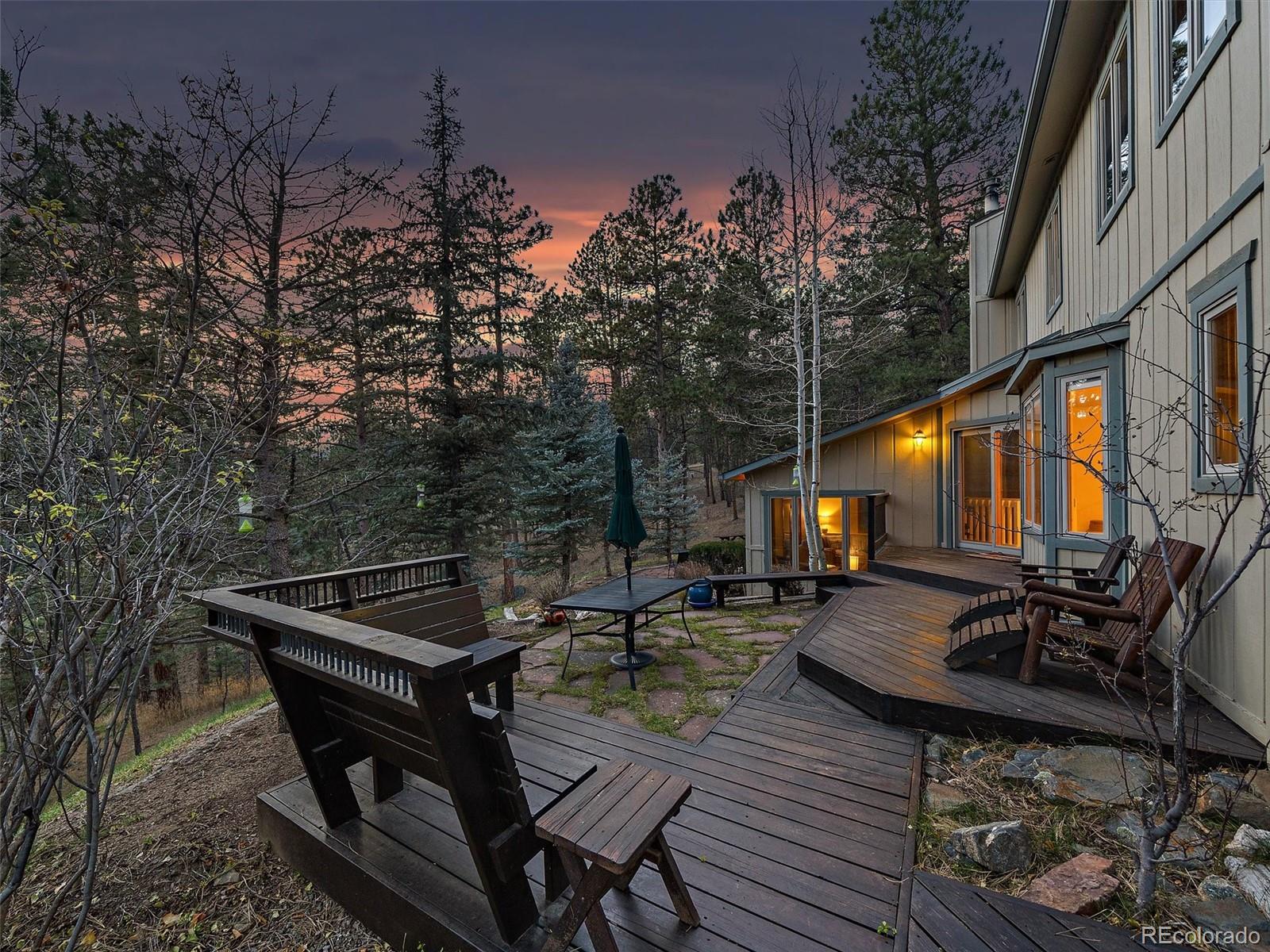 33913 Upper Bear Creek Road Evergreen, CO 80439 - Photo 30 of 45 a backyard of a house with wooden floor and outdoor seating