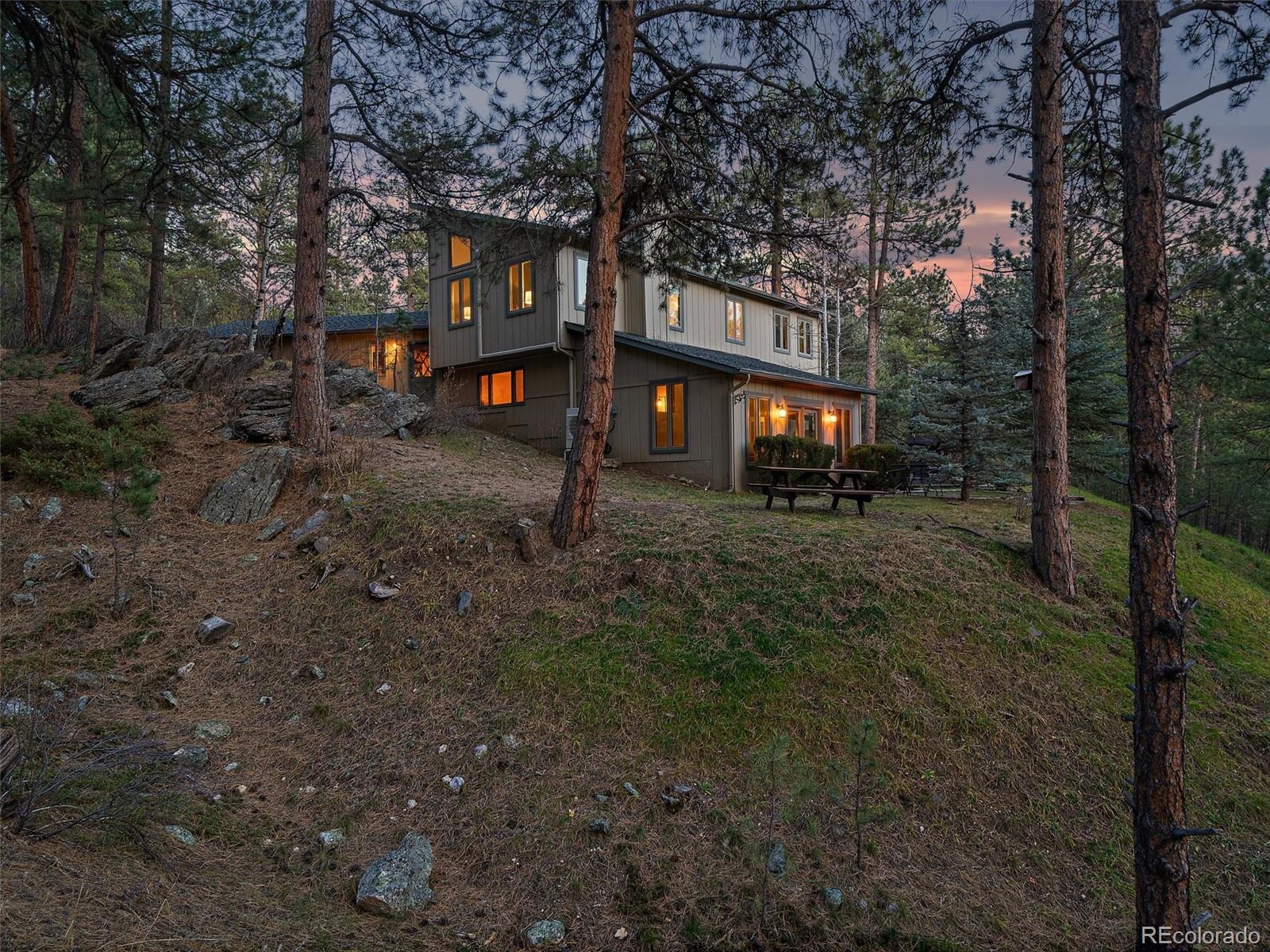 33913 Upper Bear Creek Road Evergreen, CO 80439 - Photo 41 of 45 a front view of a house with a yard