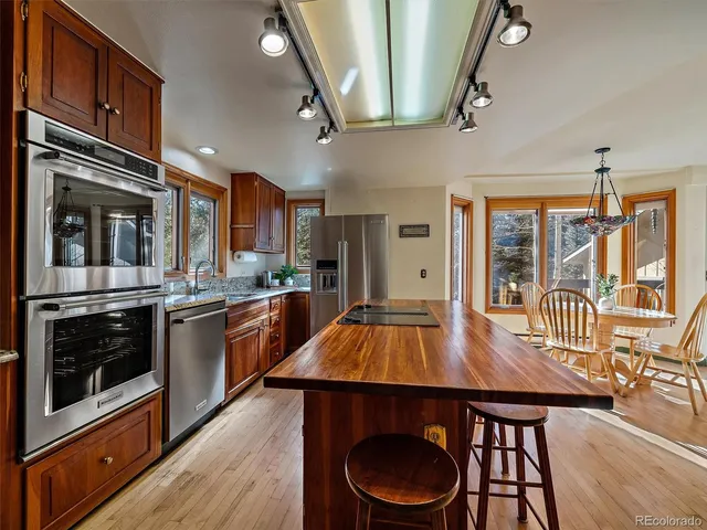 a kitchen with stainless steel appliances a dining table and chairs