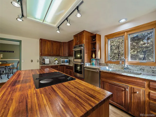 a kitchen with stainless steel appliances kitchen island granite countertop a stove and cabinets