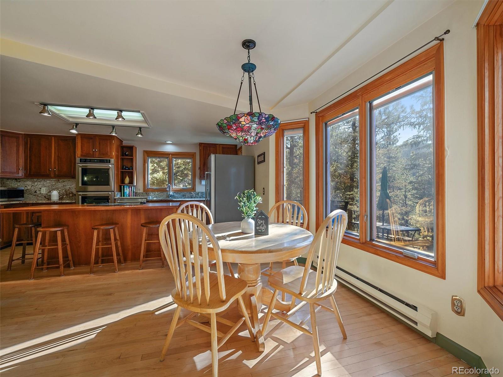 33913 Upper Bear Creek Road Evergreen, CO 80439 - Photo 8 of 45 a dining room with furniture a chandelier and window