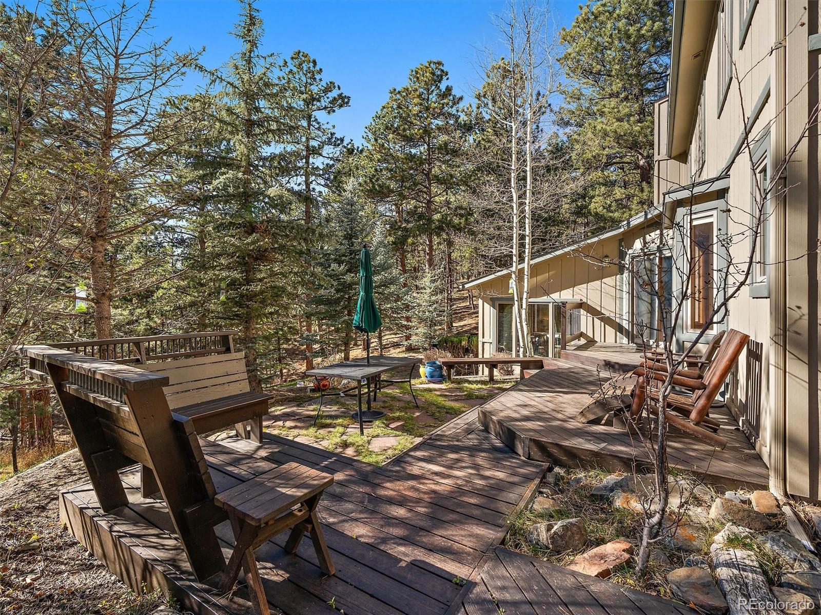 33913 Upper Bear Creek Road Evergreen, CO 80439 - Photo 9 of 45 a view of a patio with table and chairs and potted plants
