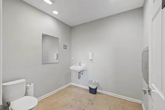 a bathroom with a toilet sink and mirror