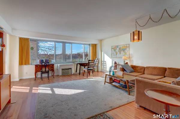 a living room with furniture and a flat screen tv with wooden floor