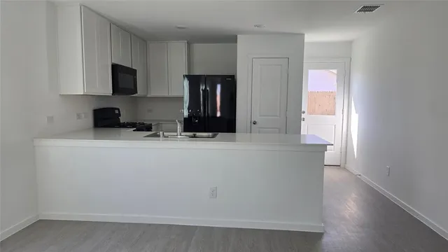 a kitchen with stainless steel appliances a refrigerator sink and microwave