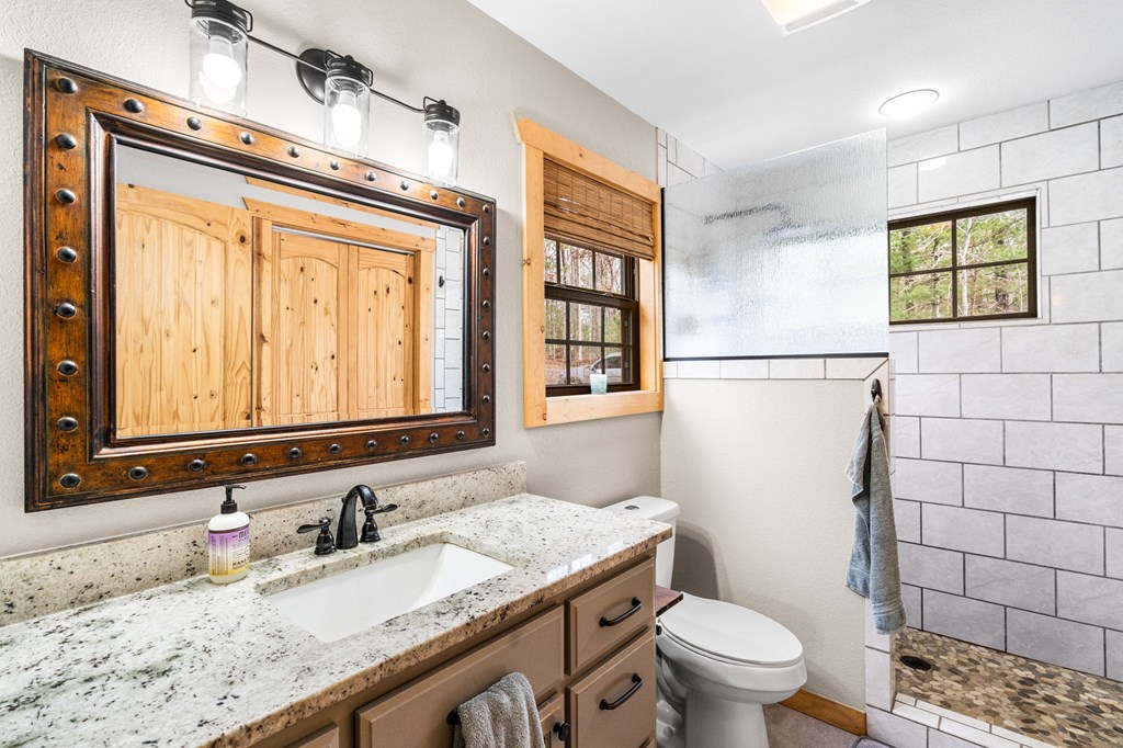 482 Tsalagi Trail Murphy, NC 28906 - Photo 14 of 44 a bathroom with a granite countertop sink toilet mirror vanity and shower