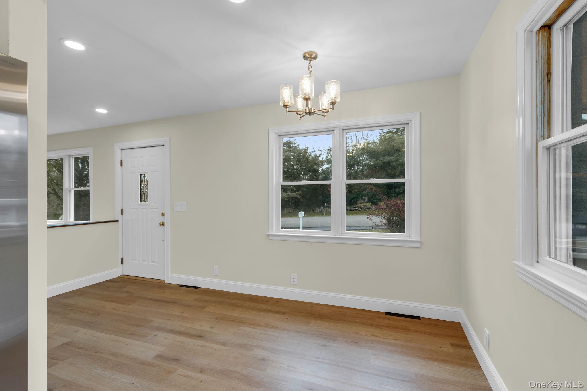 21 Reading Road Patterson, NY 12563 - Photo 10 of 39 an empty room with wooden floor chandelier and windows