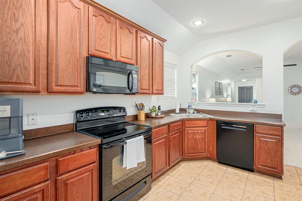 3521 Camino Real Trail Denton, TX 76208 - Photo 7 of 28 a kitchen with stainless steel appliances granite countertop a stove sink and cabinets
