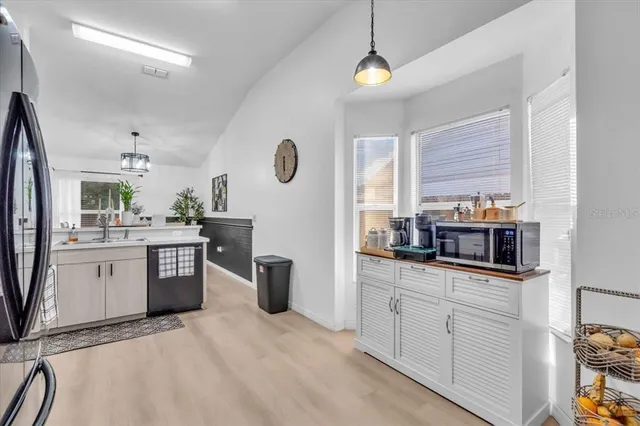 a kitchen with stainless steel appliances a sink a stove a refrigerator cabinets and a window