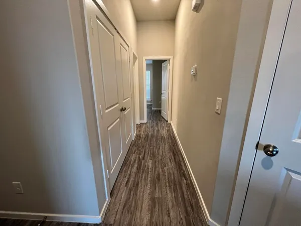 a view of a hallway with wooden floor and staircase