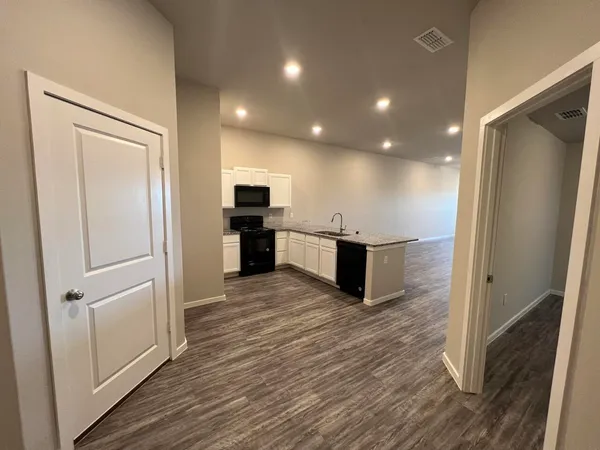 a view of kitchen with stainless steel appliances a refrigerator and wooden floor