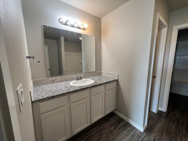 a bathroom with a granite countertop sink and a mirror