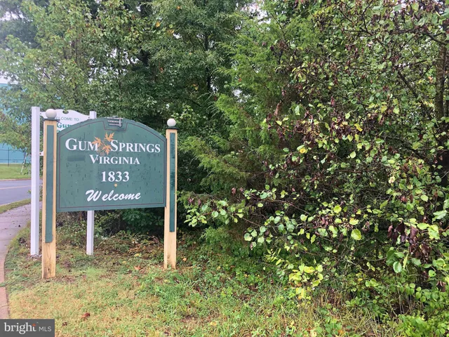 a sign that is sitting in front of a tree