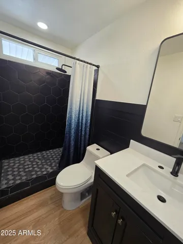 a bathroom with a sink a toilet a shower and a mirror