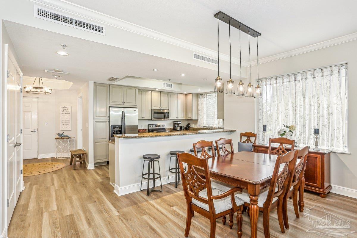 608 Lost Key Drive, Unit 201C Perdido Key, FL 32507 - Photo 15 of 42 a view of a dining room and livingroom with furniture wooden floor a chandelier