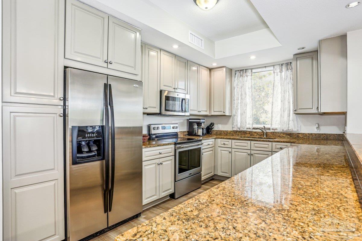 608 Lost Key Drive, Unit 201C Perdido Key, FL 32507 - Photo 9 of 42 a kitchen with stainless steel appliances granite countertop a refrigerator a stove and a sink