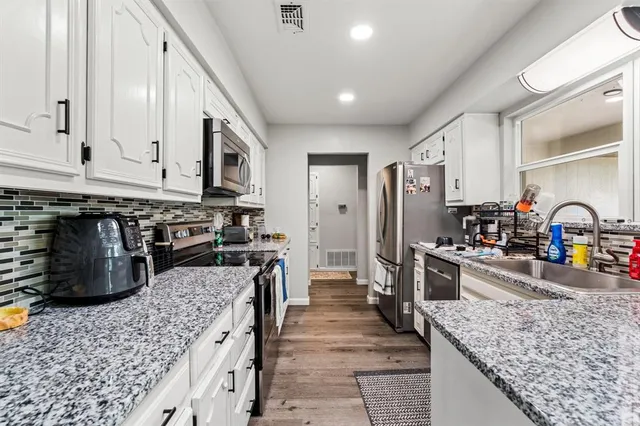 a kitchen with stainless steel appliances granite countertop a sink stove and refrigerator