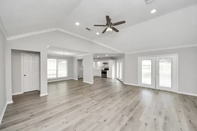 a view of empty room with wooden floor and window