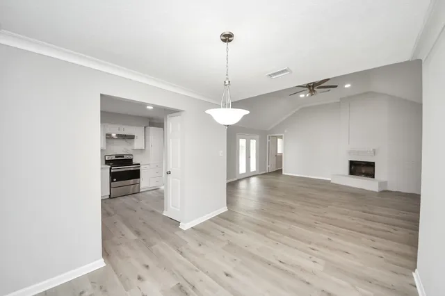 a view of a room with wooden floor and a ceiling fan