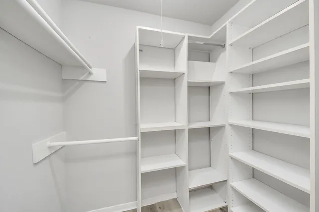a view of walk in closet with empty racks