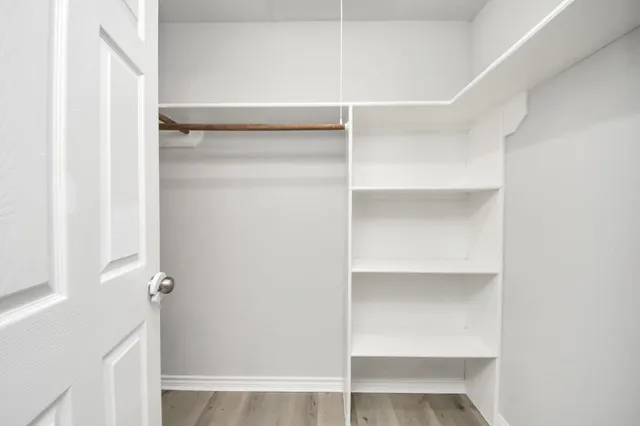 a view of walk in closet with empty racks
