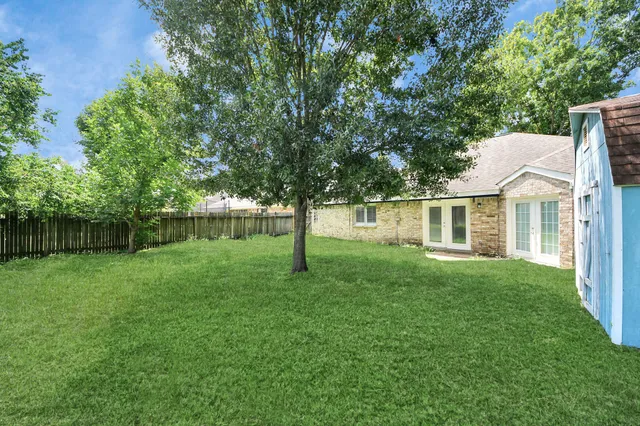 a view of a house with a yard and a tree