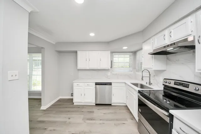 a kitchen with stainless steel appliances a sink stove and cabinets