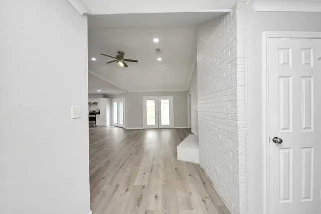 a view of empty room with wooden floor and fan