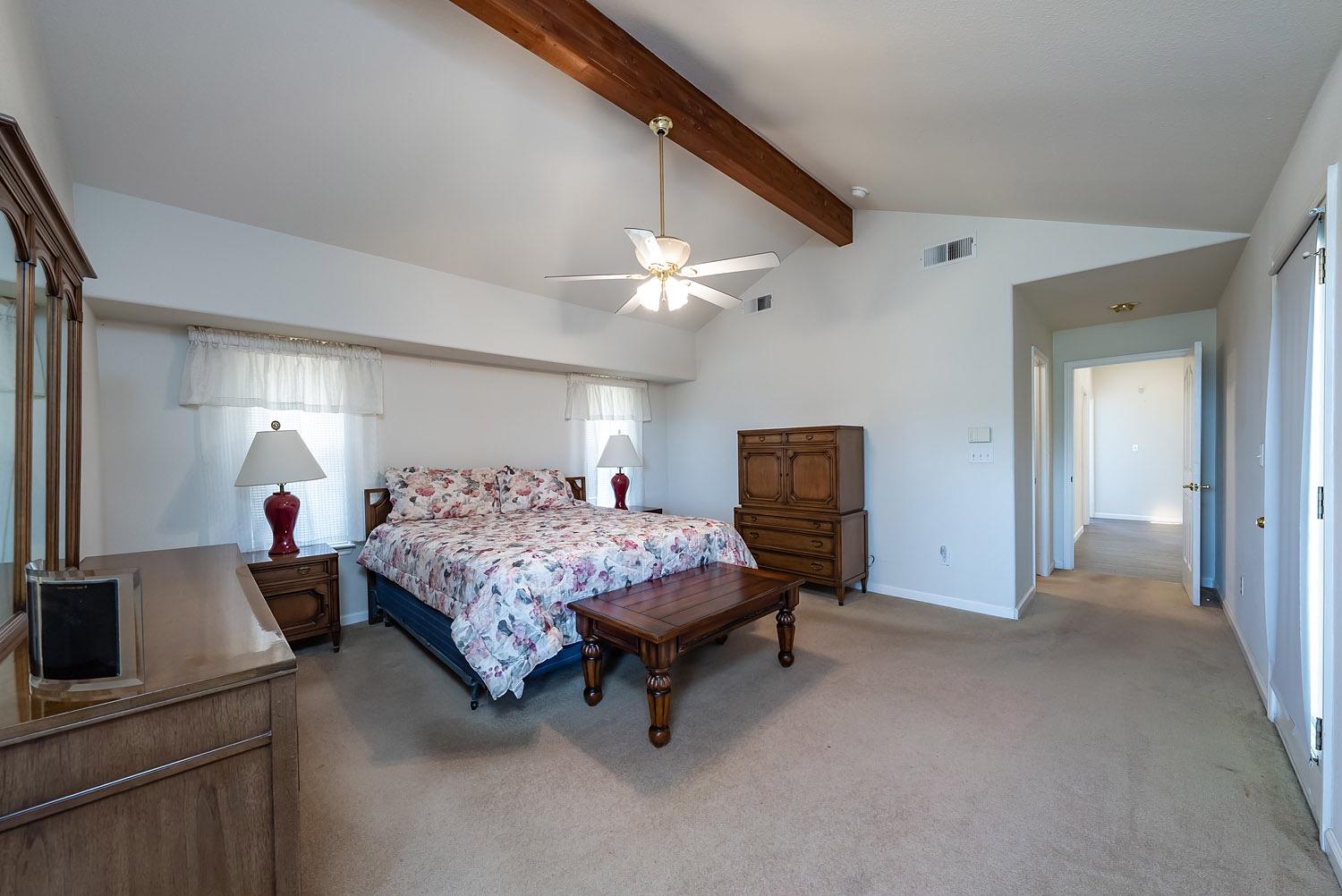 16601 La Canada Road Madera, CA 93636 - Photo 21 of 40 a spacious bedroom with a bed and a chandelier