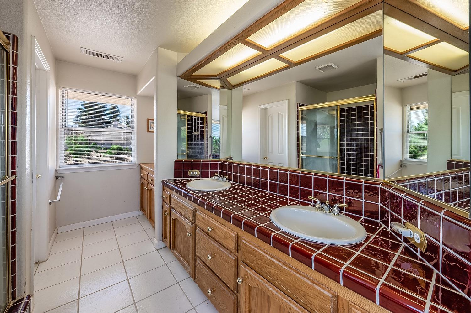 16601 La Canada Road Madera, CA 93636 - Photo 25 of 40 a bathroom with a sink a mirror and a shower