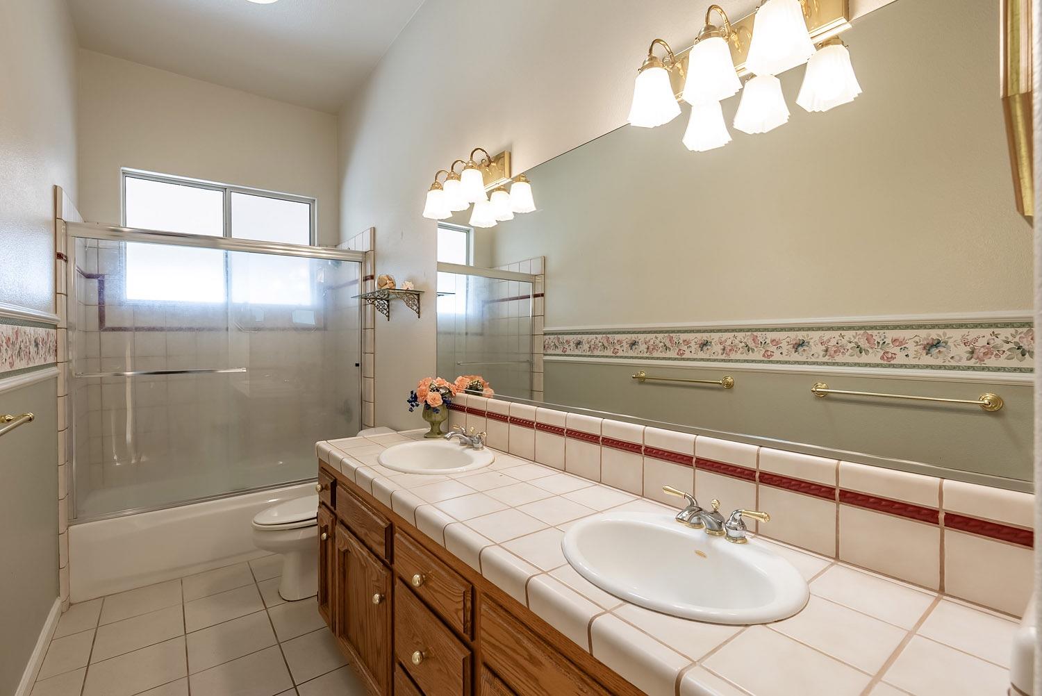16601 La Canada Road Madera, CA 93636 - Photo 26 of 40 a bathroom with a sink a double vanity and a mirror