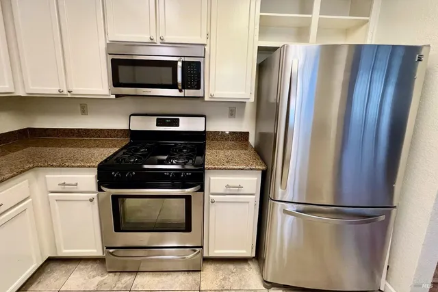 a kitchen with refrigerator a microwave and cabinets