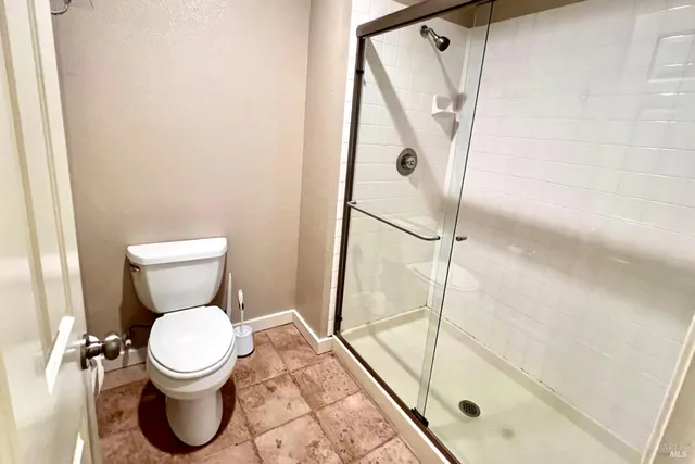 a bathroom with a toilet and a shower